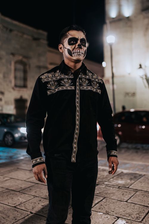 Free Man with painted skeleton face at night during Day of the Dead in Oaxaca, Mexico. Stock Photo