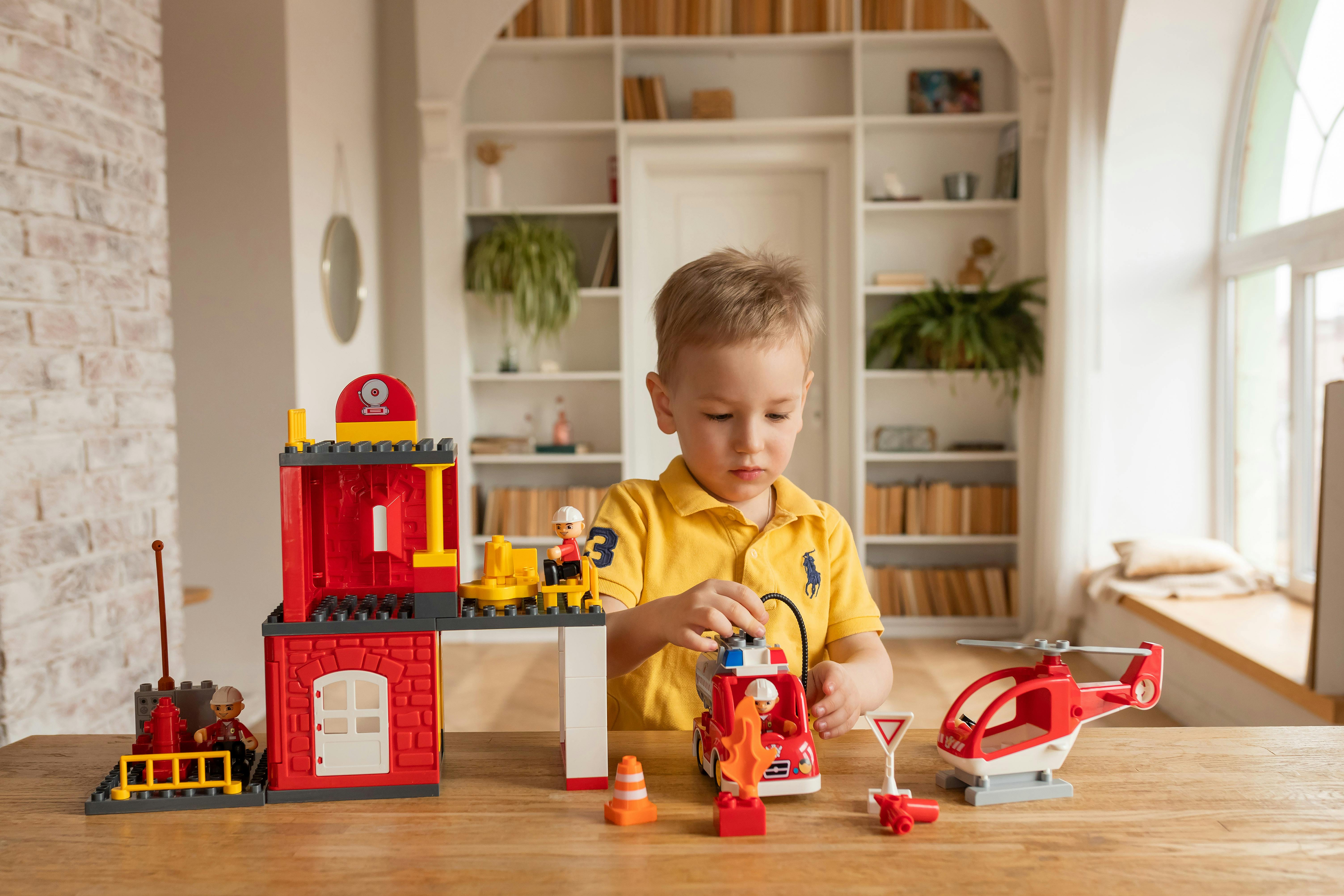 a little boy playing with a toy fire department