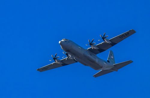 Free USAF military aircraft flying against a clear blue sky, showcasing aviation strength. Stock Photo