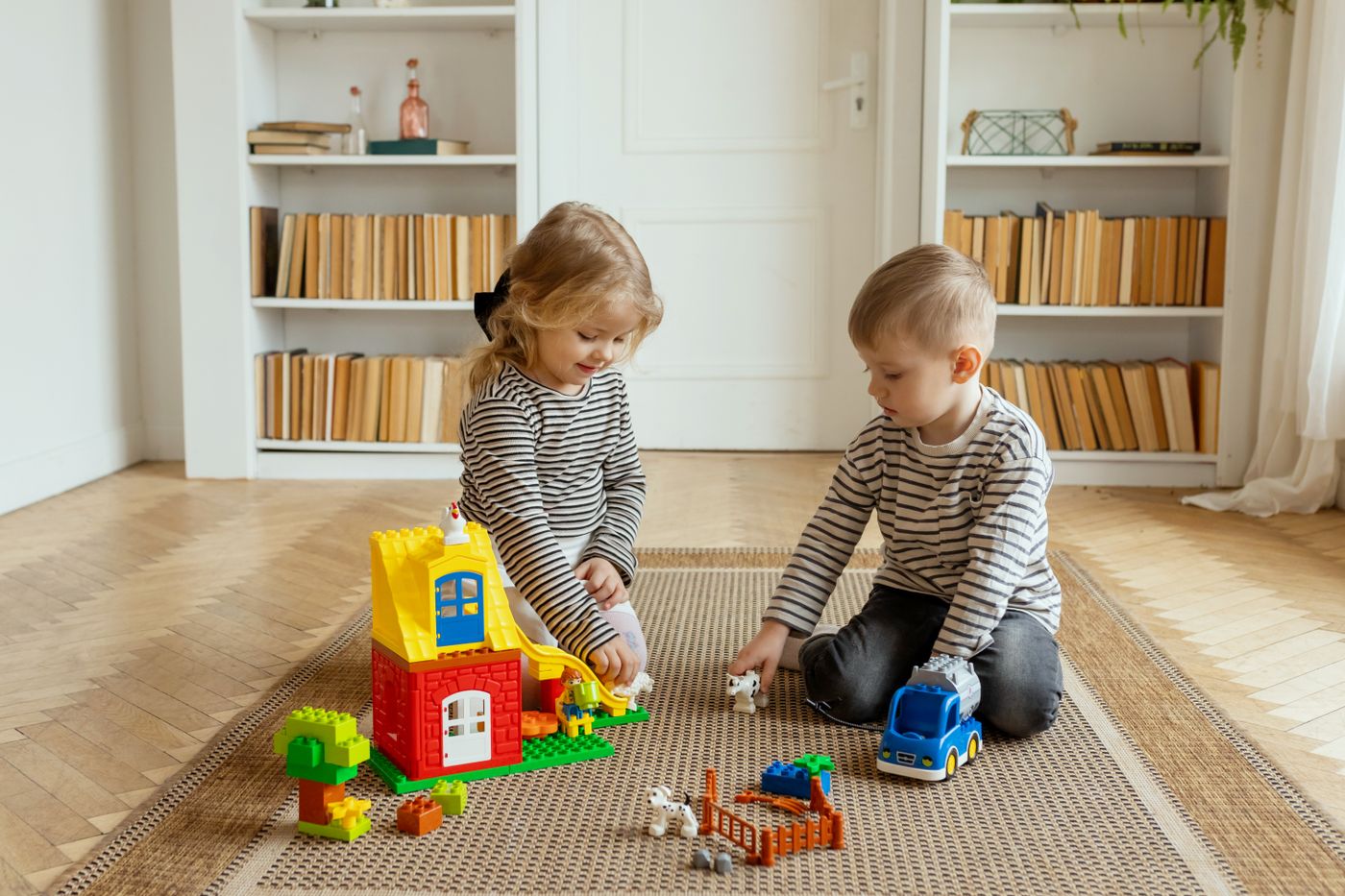 Zwei Kinder spielen gemeinsam mit buntem Spielzeug