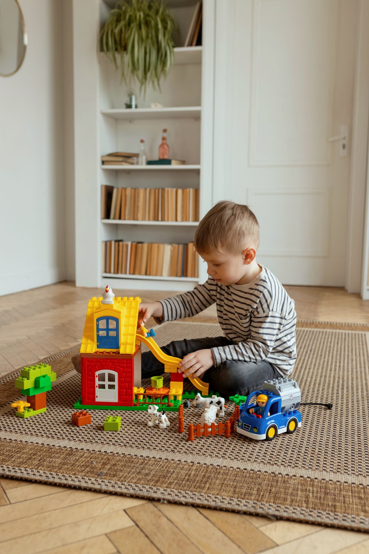 A young boy enjoying colorful building blocks in a cozy corner nook set up as a LEGO station