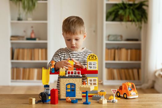 A young boy plays with colorful construction blocks at home, fostering creativity and imagination.