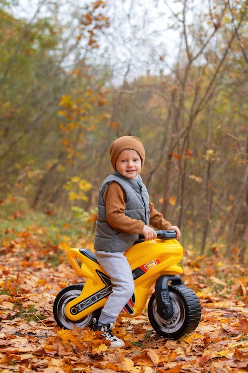 Boy on Toy Motorbike in Autumn