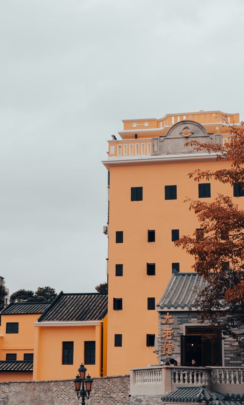 Free A striking yellow building showcasing unique architecture in an urban Asian cityscape. Stock Photo