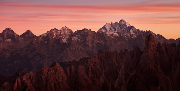 A stunning view of a mountain range at sunset with vibrant hues in the sky.