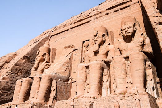 Majestic sandstone statues at the Temple of Ramesses II under a clear blue sky.
