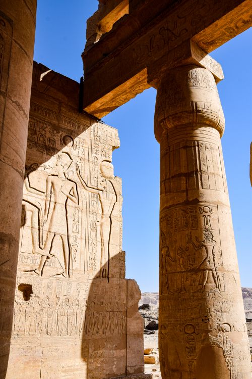 Free Sunlit ancient Egyptian temple with detailed hieroglyphs on walls and columns showcasing historic art. Stock Photo