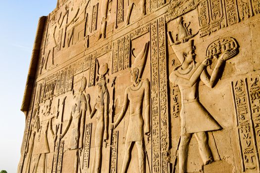 Detailed view of ancient Egyptian hieroglyphs and figures on a temple wall.