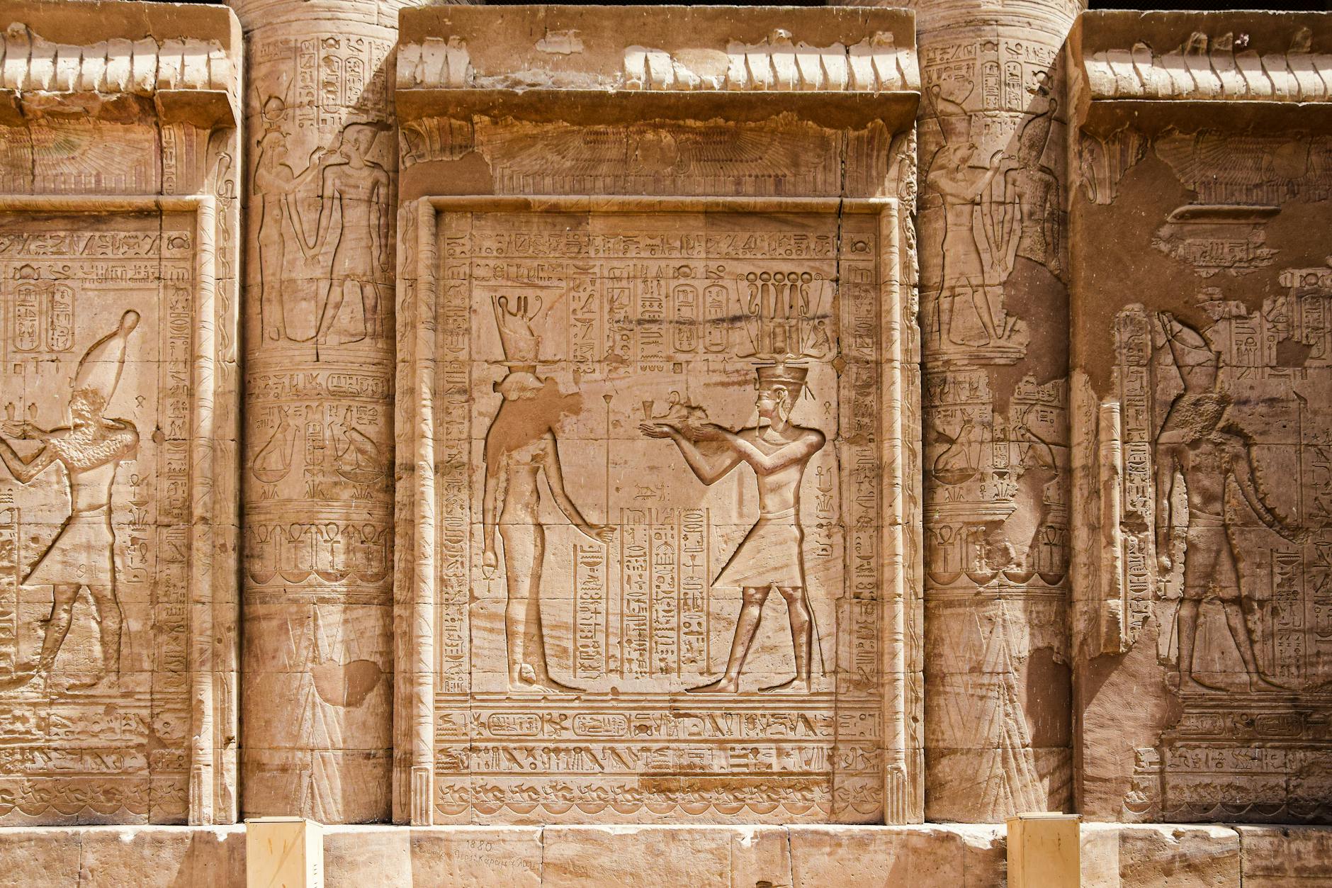 Engraved stone reliefs with intricate hieroglyphs from ancient Egyptian civilization.