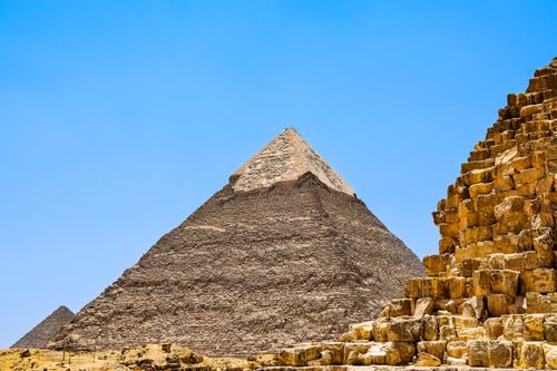 Free Iconic pyramids under a clear blue sky in Giza, capturing ancient history. Stock Photo