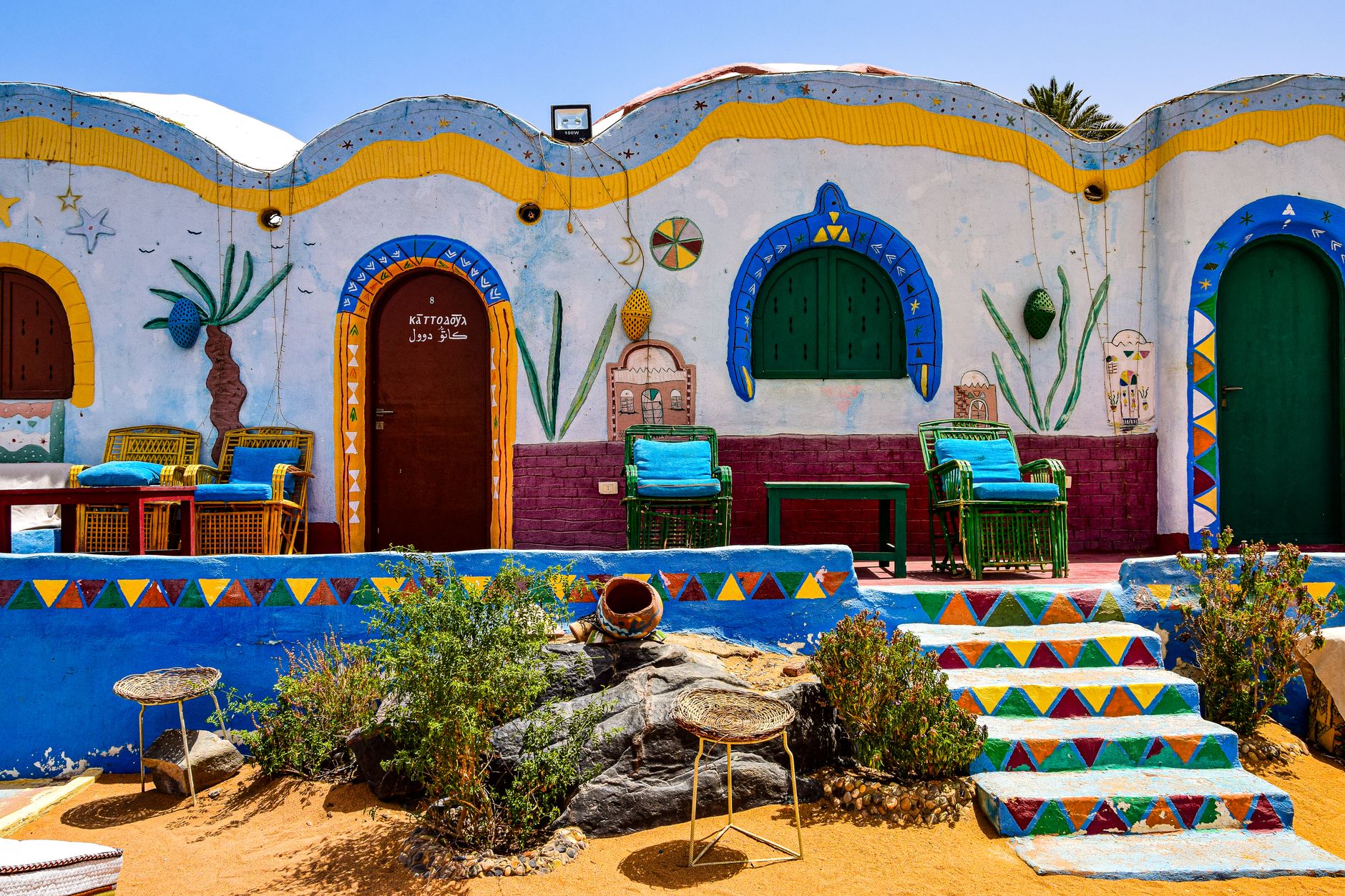Vibrant Nubian house facade with colorful walls and traditional decor in Egypt's rural area.