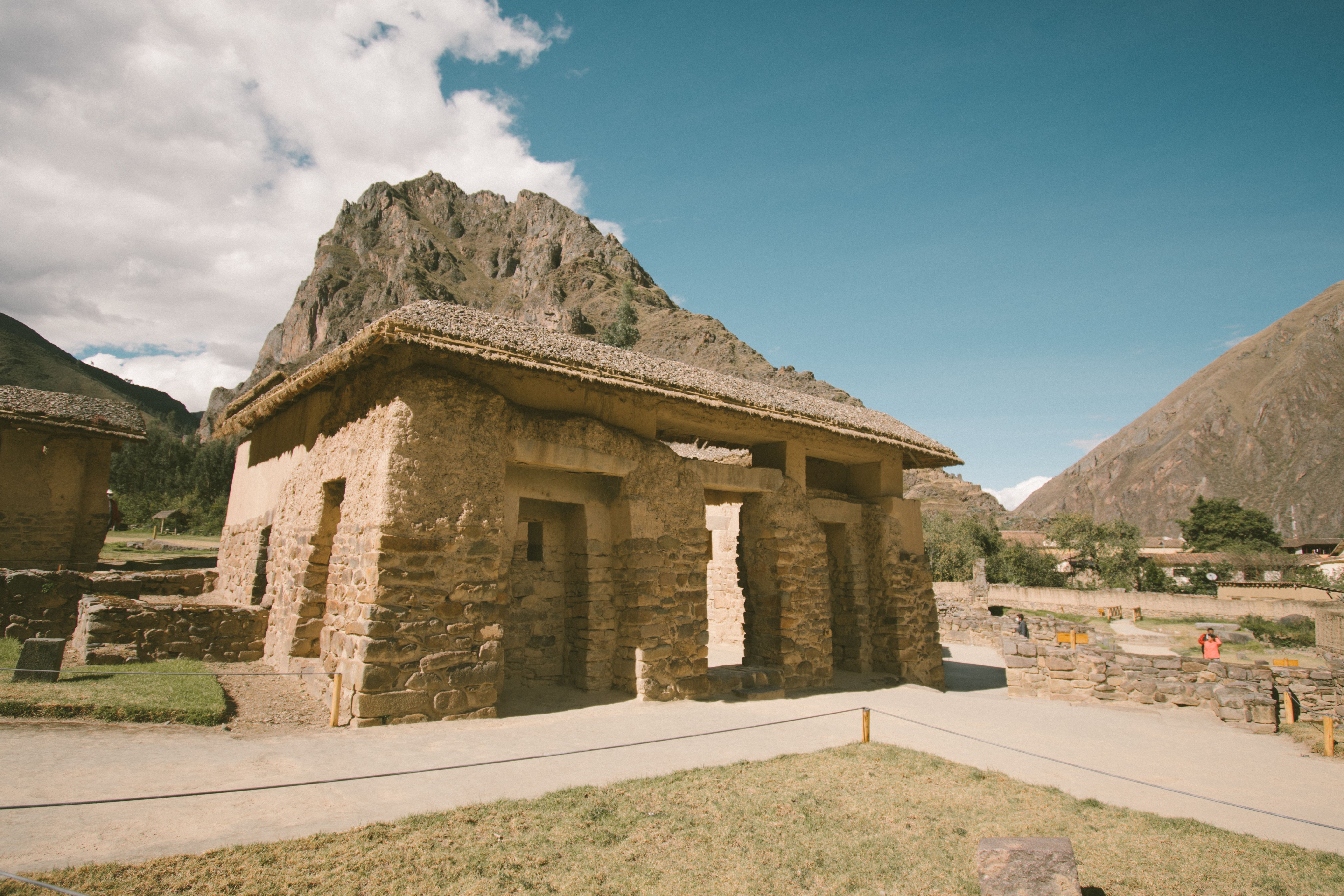 Explore the stone ruins against majestic mountains in Ollantaytambo, Peru.