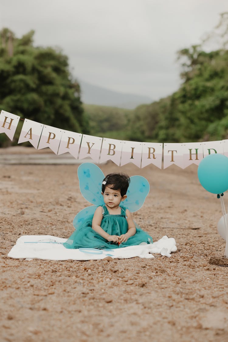 Girl Sitting In Green Dress And With Birthday Wishes Behind