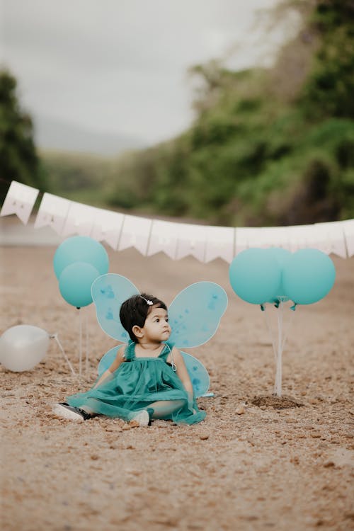 Free A Little Girl in a Dress Sitting among Birthday Decorations  Stock Photo