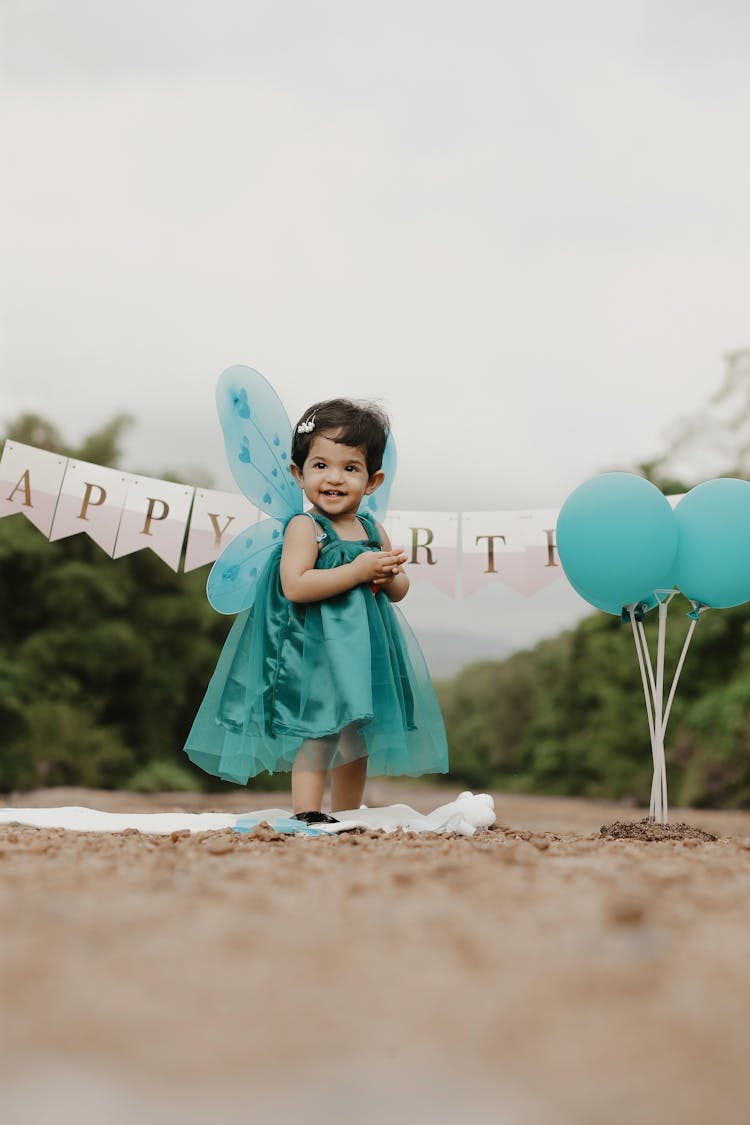 Smiling Girl In Green Dress With Butterfly Wings