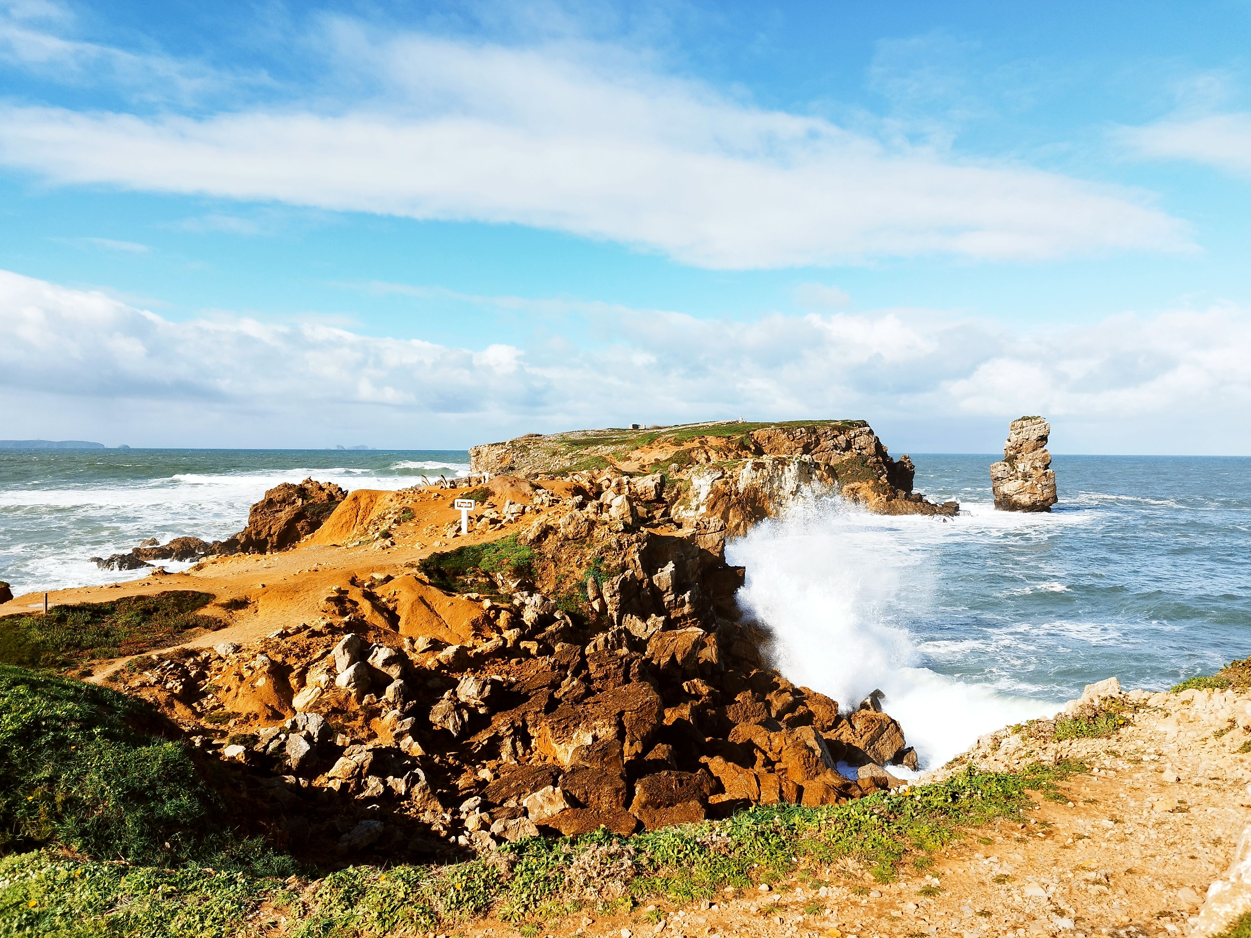 Captivating view of Papoa Peninsula with waves crashing against rocky coast under a clear blue sky.
