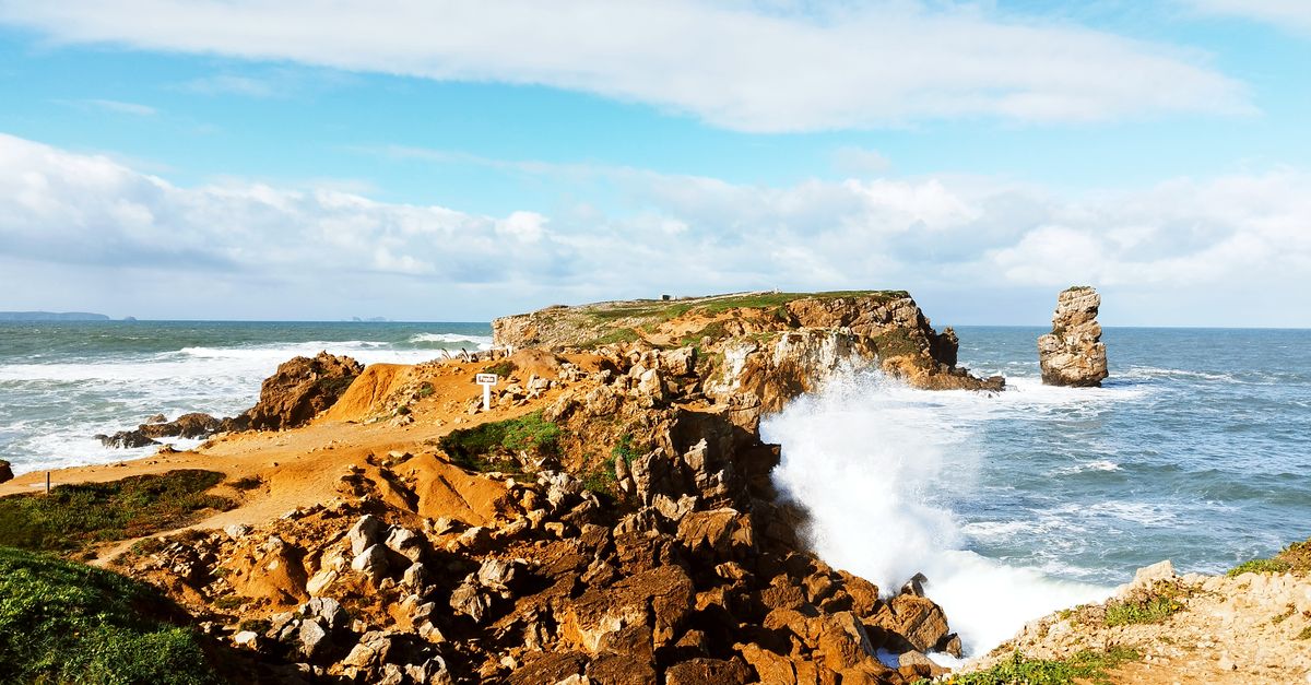 Captivating view of Papoa Peninsula with waves crashing against rocky coast under a clear blue sky.