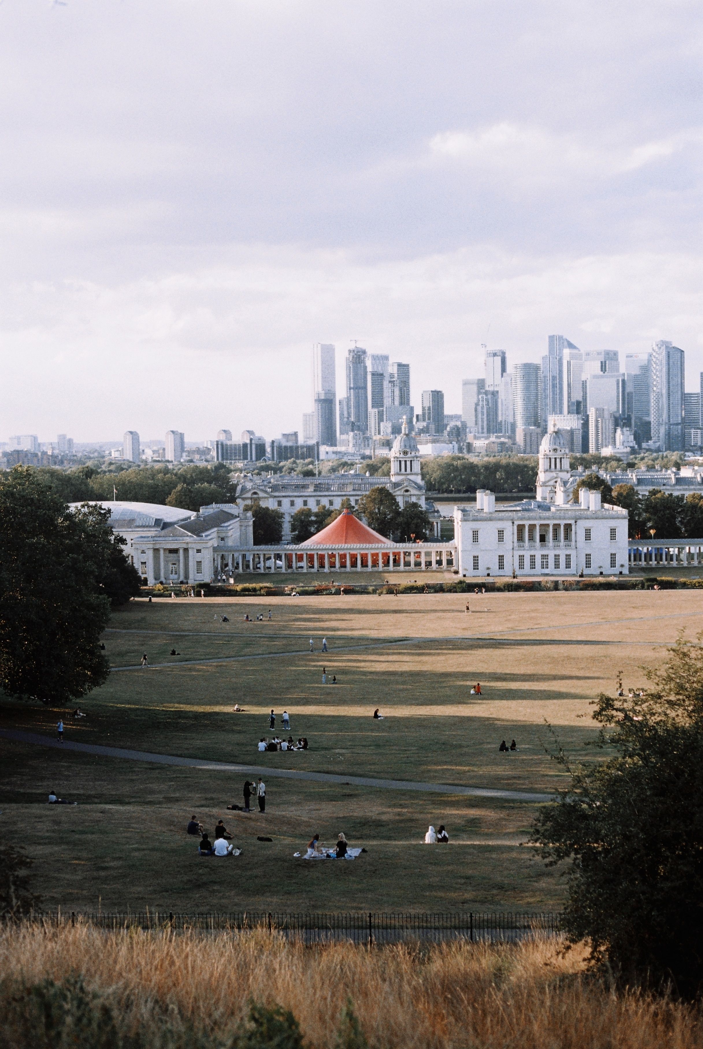 People Relaxing in an Open Park with a City Skyline in the Background ...
