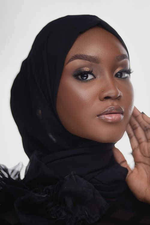 Free Stunning close-up portrait of a stylish black woman wearing a hijab against a white background. Stock Photo