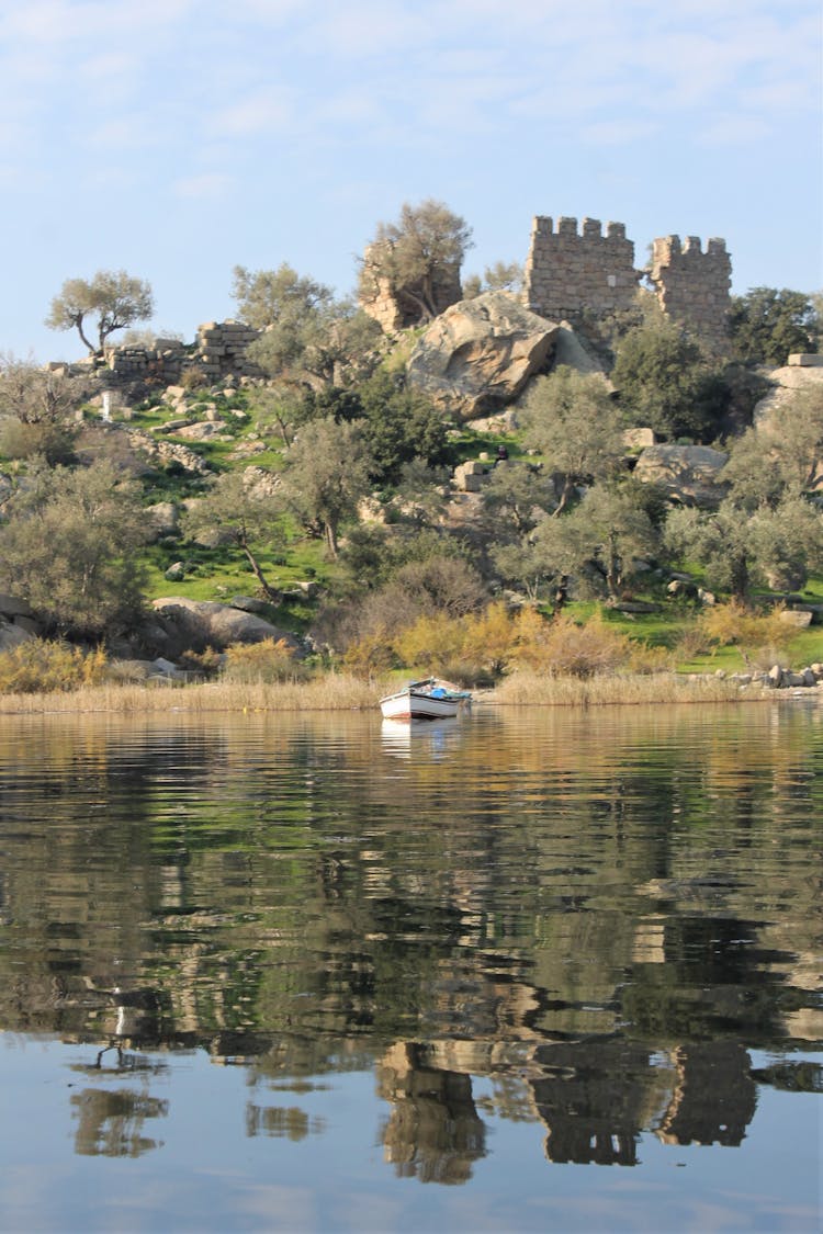 Ruins Of A Castle On A Hill By A Body Of Water 