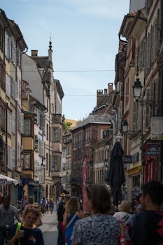 Bustling street scene in Strasbourg, France with historic architecture and lively atmosphere.