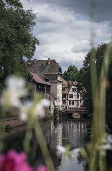 Scenic view of traditional buildings along a canal in Strasbourg, France. Perfect for travel-themed projects.