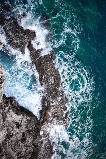 A breathtaking aerial view of rough waves crashing against the rocky coastline of Antalya, Türkiye.