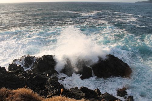 Free Powerful ocean waves crashing against rugged rocks creating dramatic sea spray. Stock Photo