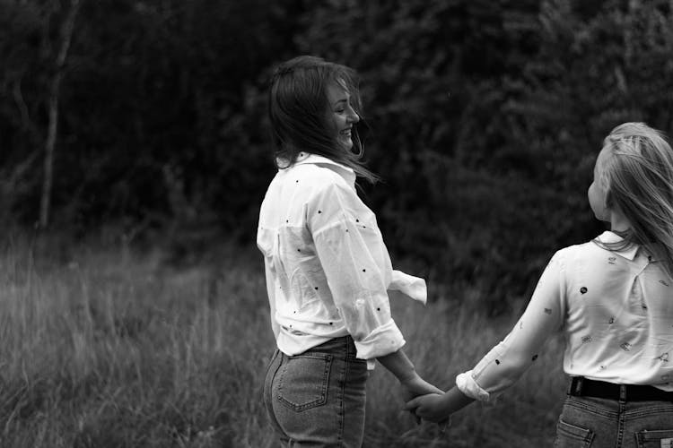 Black And White Photo Of A Mother And Daughter Holding Hands 