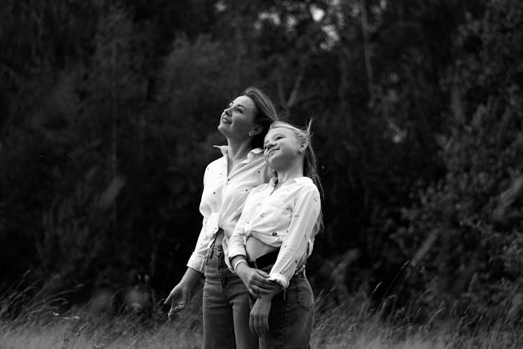 Black And White Photograph Of A Mother And Daughter Standing In A Forest Glade