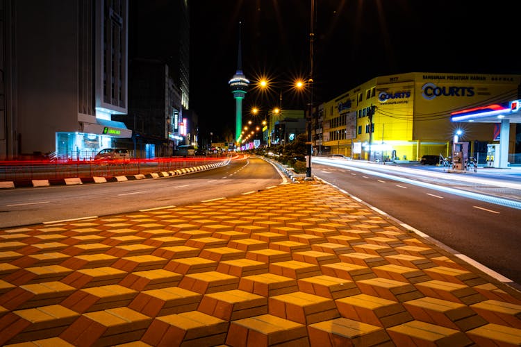 Empty Streets And Illuminated Tower Behind At Night