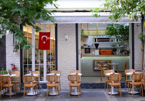 Cozy café patio with Turkish flag, elegant chairs, and welcoming atmosphere.