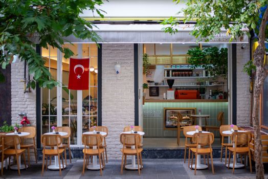 Charming café exterior with Turkish flag, outdoor seating, and urban ambiance, inviting atmosphere.