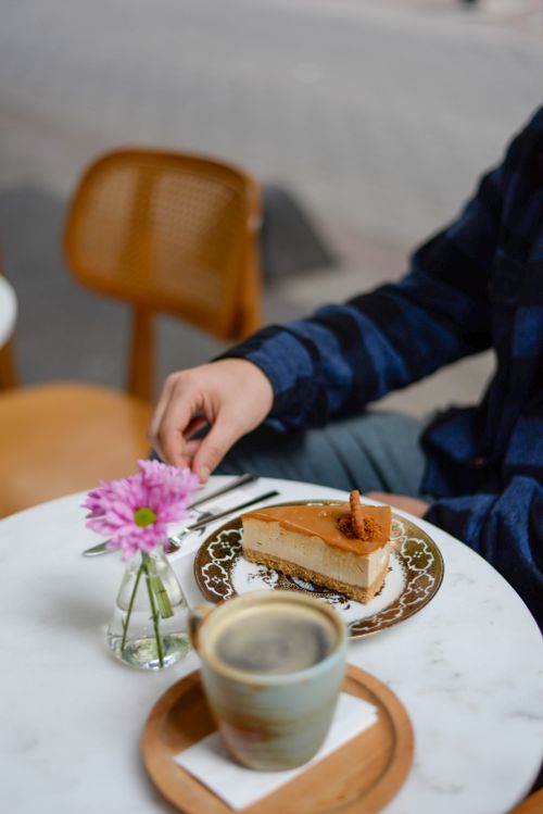 Free Enjoying dessert and coffee at a charming outdoor café. Stock Photo