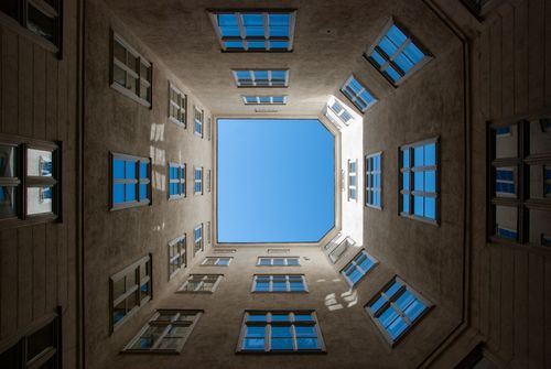 Free Upward view of a symmetrical courtyard in Vienna with a clear blue sky. Stock Photo