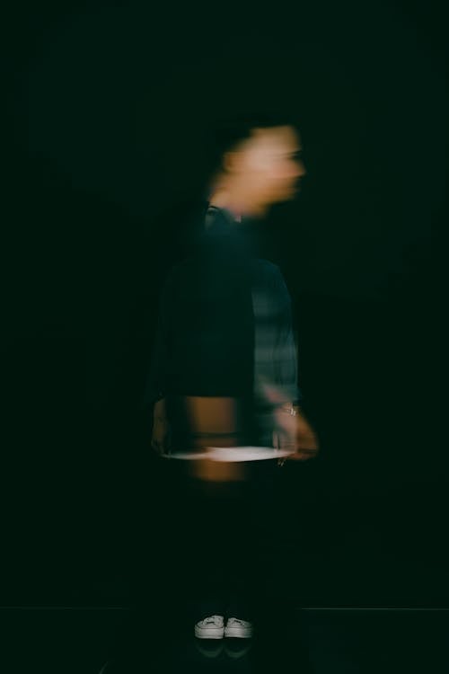 Blurred Man Walking in Darkness