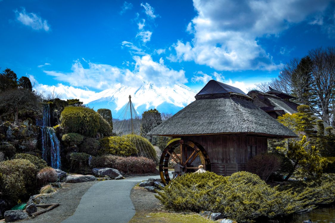 Traditional Japanese thatched-roof building with Mt. Fuji in the background