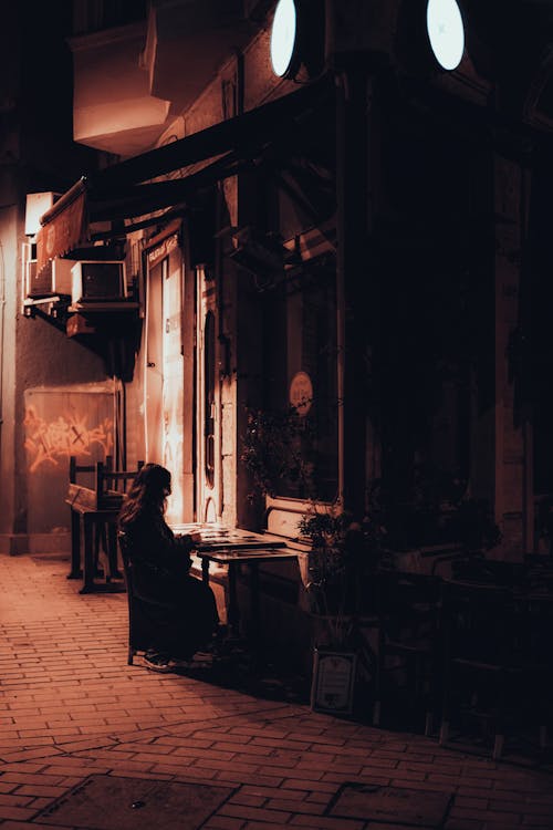 Woman Sitting in Narrow Alley in Istanbul at Night