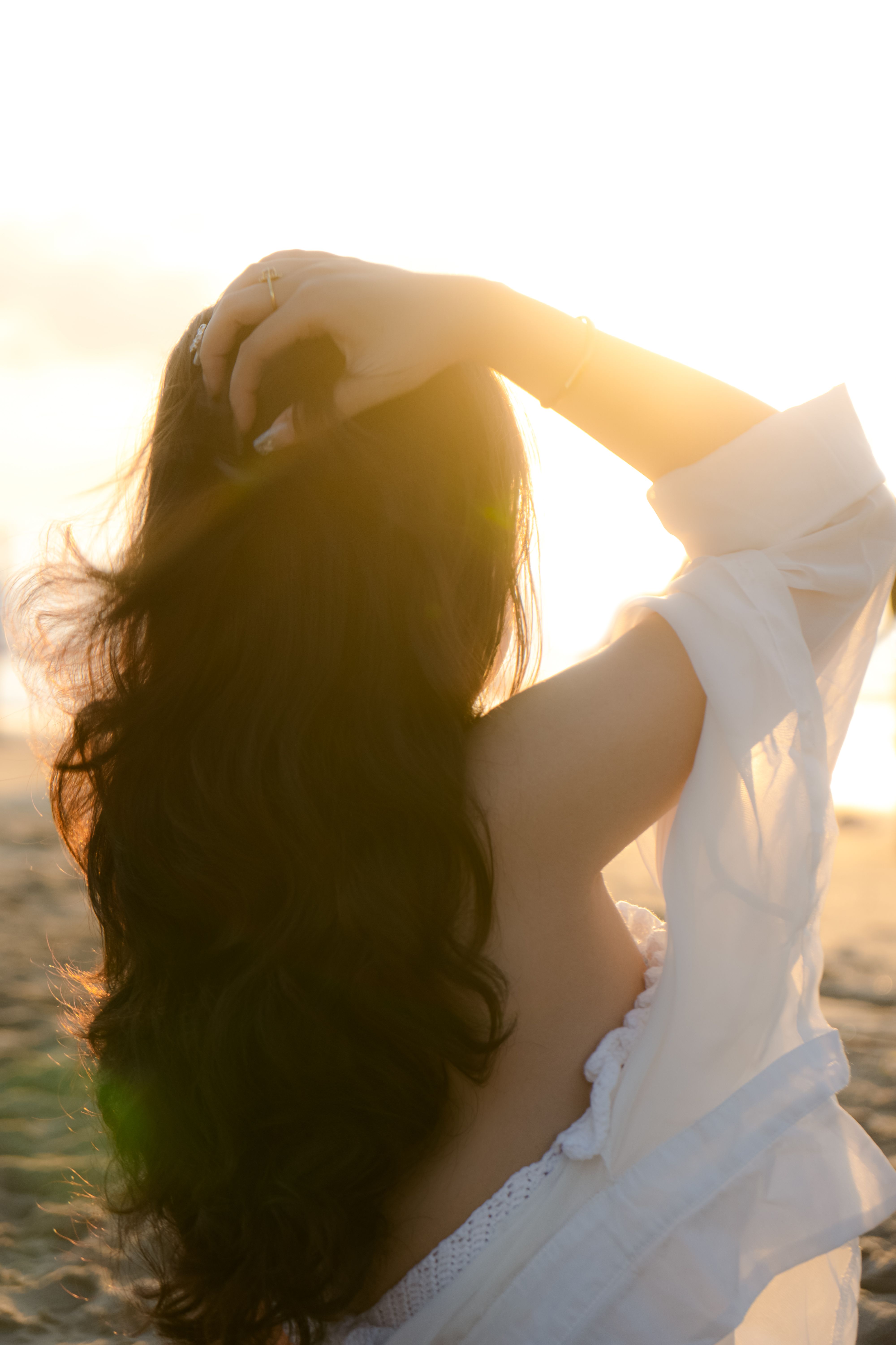 Elegant woman with long hair enjoying a sunset at Vũng Tàu beach, capturing serene beauty.