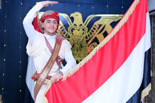 Man in Traditional Clothing and with Flag of Indonesia