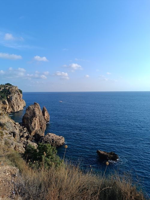 Free Breathtaking view of rocky coastline and blue ocean under a clear sky. Stock Photo