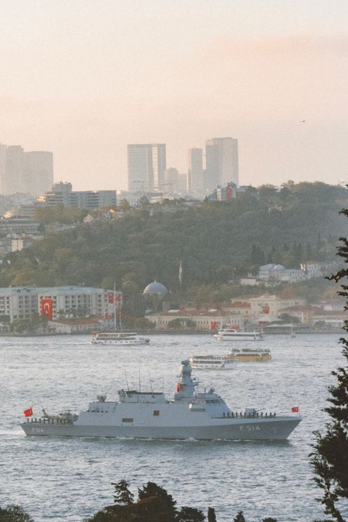 Free A military vessel cruises through Istanbul's Bosphorus with cityscape backdrop. Stock Photo