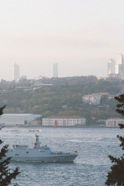 A Turkish warship travels through the Bosphorus with Istanbul's skyline in the background.