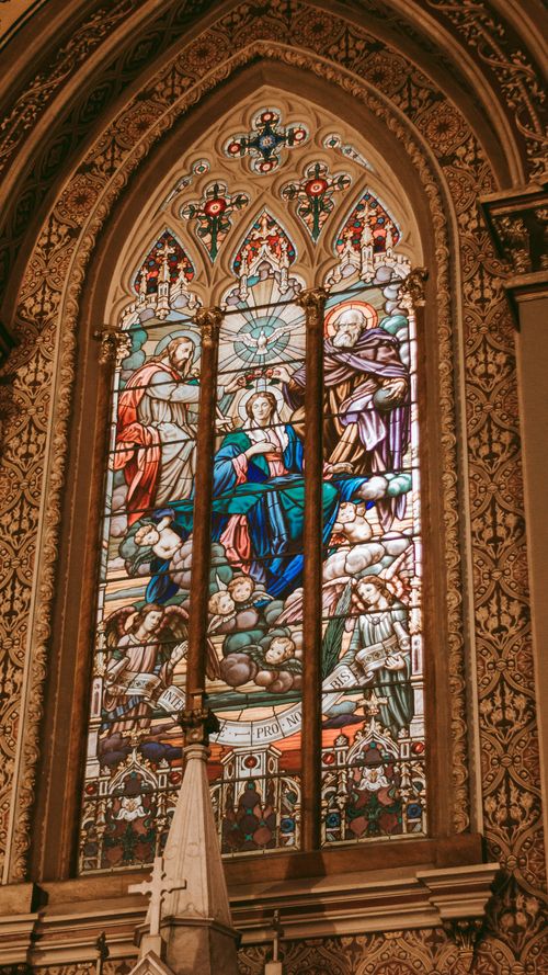 Free Exquisite stained glass window showcasing detailed religious imagery in a gothic cathedral. Stock Photo