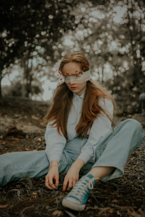 Portrait of a Blindfolded Woman Sitting on the Ground