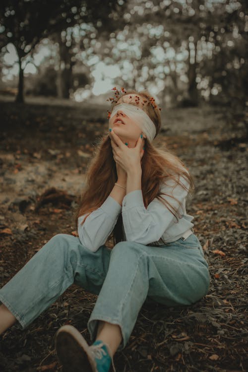 Blindfolded Woman Sitting on the Ground