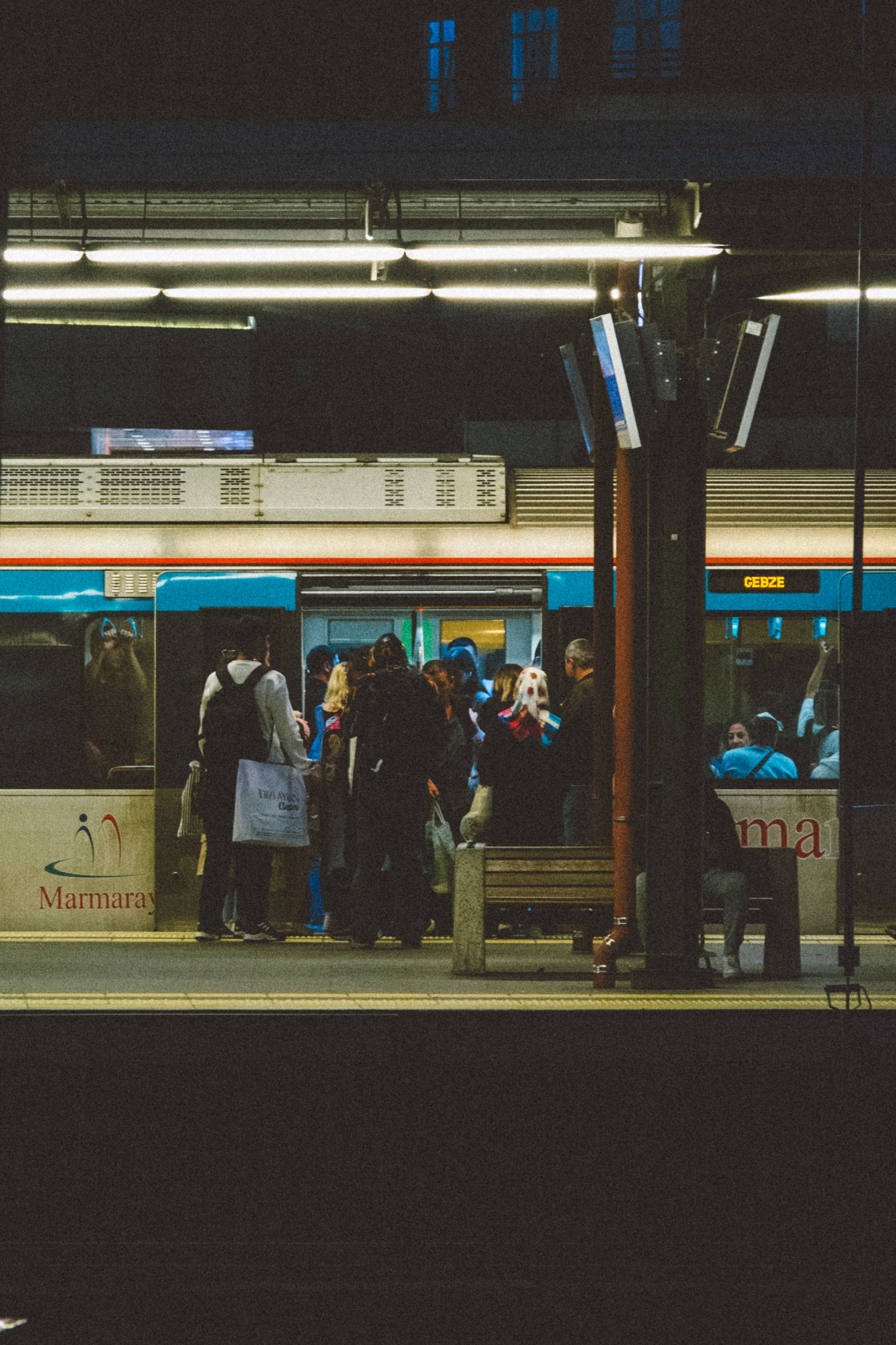 Passengers boarding a train at a dimly lit station, capturing urban travel.
