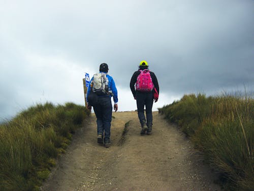 People Hiking on Footpath on Hill