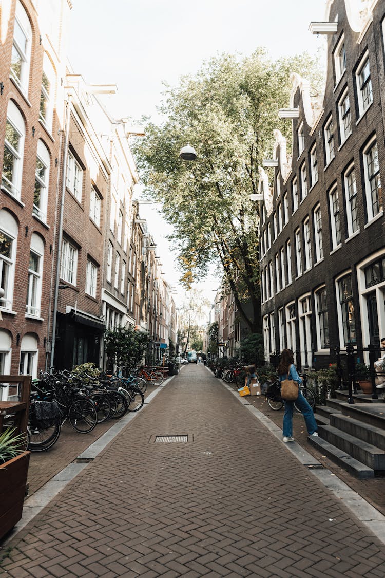 Bicycles On Sidewalk In Alley In Amsterdam, Netherlands