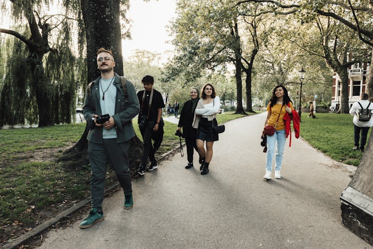 Group Of Photographers Walking In The Park Looking For The Perfect Shot